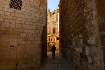 Silhouette of a tourist walking in an alleyway in the Old City of Jerusalem, Israel. The Old City...