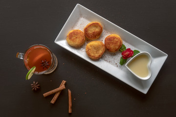 Cheesecakes on a rectangular white plate with tea