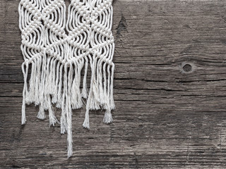 Macrame. Macrame weaving. White thread, wooden background, closeup