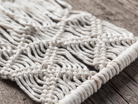 Macrame. Macrame weaving. White thread, wooden background, closeup