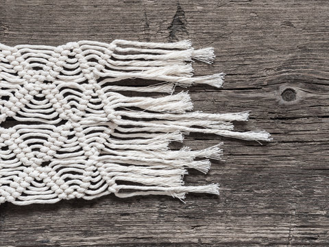 Macrame. Macrame weaving. White thread, wooden background, closeup