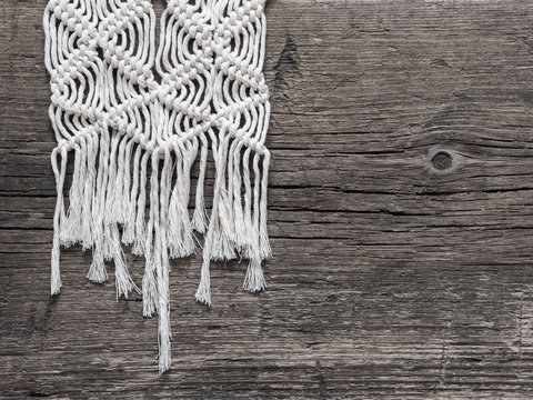 Macrame. Macrame weaving. White thread, wooden background, closeup
