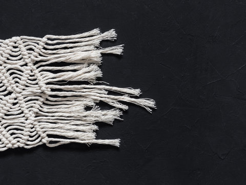 Macrame. Macrame weaving. White thread, black background, closeup