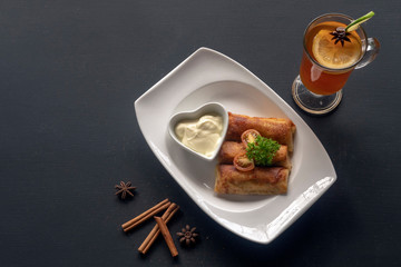Pancakes on a rectangular white plate with tea