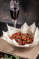 Concept of Spanish cuisine. Snack to wine or beer. Spicy almonds with pecias, rosemary, smoked paprkika, chili pepper, olive oil and salt. The dish is served on a parchment plate. background image
