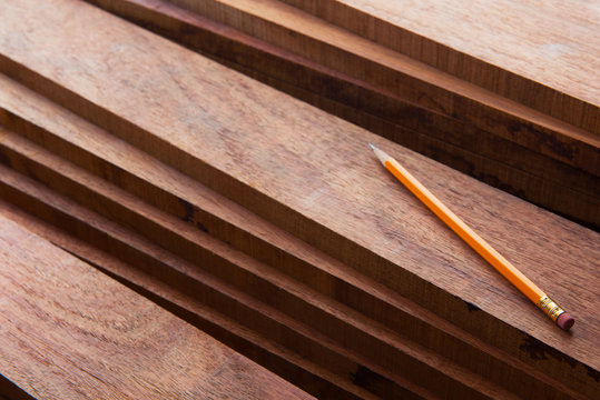 Hard wood lumber stacked with pencil on top. Wood working or interior carpentry.