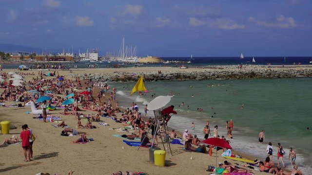 Lifeguard on an observation chair at a crowded Mediterranean sandy beach, Barcelona Beach, Catalonia, Spain, Europe