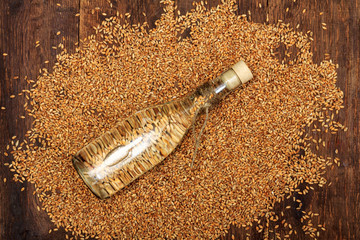 Spirits or vodka from wheat in shot rustic glass with wheat grains and ears