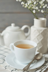 Beautiful bright tea set up. White ceramic tea pots and tea ingredients, on top of the white table. Copy Space. Spring Greeting Card Template. Cup of tea on table. Kitchen utensils