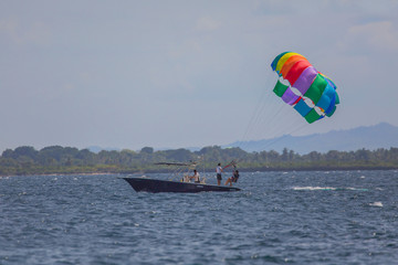 couple enjoy parasailing on a sunny vacation day on the tourist destination Mactan Island