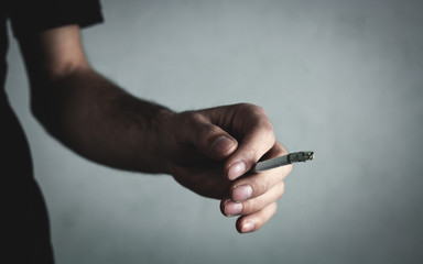 Caucasian man holding cigarette. Smoking