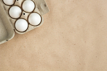 Cardboard egg rack with eggs on rustic background with copy space