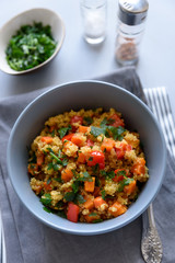 Healthy vegan bowl with quinoa, pumpkin, pepper and carrot on gray wooden background. Selective focus