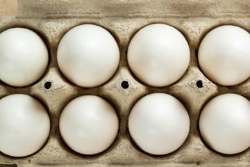 Cardboard egg rack with eggs on rustic background with copy space