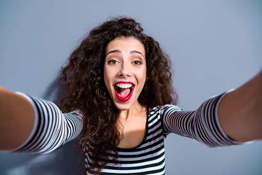 Close up picture photo portrait of crazy excited pretty optimistic with open mouth surprised amazed using device for making taking selfie hold hands isolated grey background