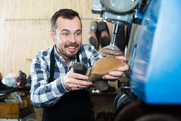 Male worker repairing shoe