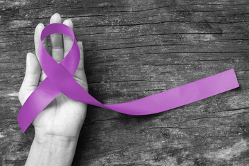Alzheimer's Disease (AD) Awareness with purple ribbon (clipping path) on helping hand support for World Alzheimers day (month) concept