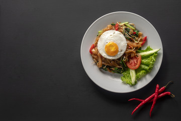 Asian dish fried noodles with egg and seafood or beef or chicken