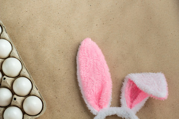Top view of bunny ears easter holiday accessory and white egg on rustic background