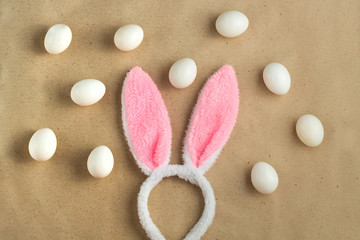 Top view of bunny ears easter holiday accessory and white egg on rustic background