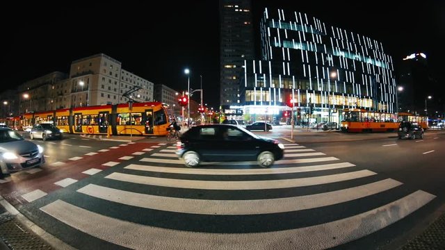 Horizontal shooting of zebra crossing at evening. Amazing street with cars and modern building. Capital city. Poland. Warsaw. Autumn time. Outdoors. Traffic concept, transport, downtown