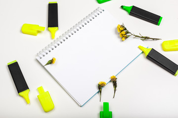 highlighters and  blank notepad paper sheet flat lay on a desk