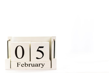 the day of February on a white clear background. a wooden desktop calendar that reminds us of what date we are today.