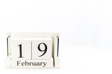 the day of February on a white clear background. a wooden desktop calendar that reminds us of what date we are today.