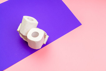 White toilet paper rolls on bright color block background