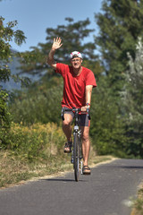 Obraz premium Young man with red sportswear on the bike road from Hungary