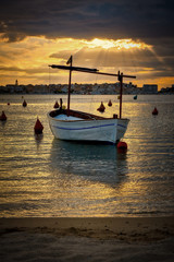 Beautiful orange colors early in the morning in Spain with a traditional Spanish boat