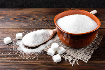 Sugar on wooden background.