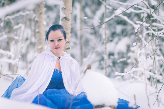 Lady in blue in midst of finnish winter forest