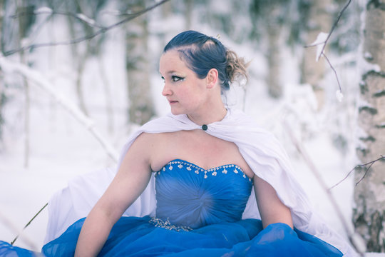 Lady in blue in midst of finnish winter forest