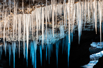 Many icicles hanging from the ceiling of the cave.
