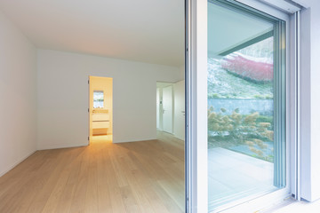 Obraz premium Empty room with parquet and window reflecting the garden