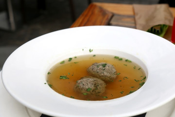 Plate of meat soup with two meatballs. Selective focus.