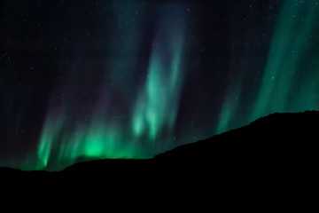 Amazing Aurora Borealis in North Norway (Ringvassoy), mountains and sea in the background