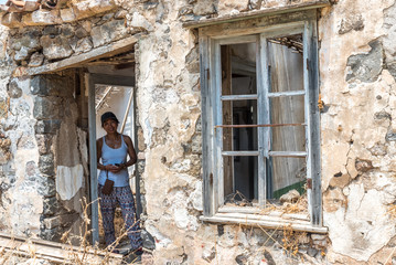 Woman standing in ruins of abandoned house