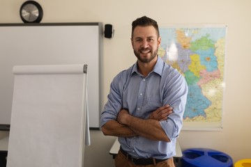 School teacher with arms folded looking at camera 