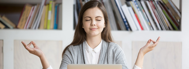 Horizontal photo businesswoman employee student meditating sitting near laptop at workplace, stress...