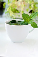 Tasty fresh herbal tea with green peppermint and basil essential oils