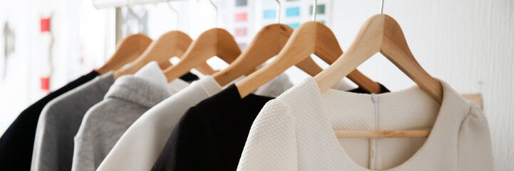 Close up photo stylish fashion white grey black colors women clothes choice at designer store hang...