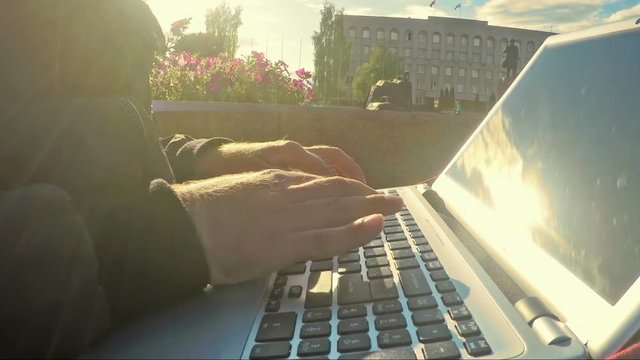 Young modern freelancer working on laptop closeup
