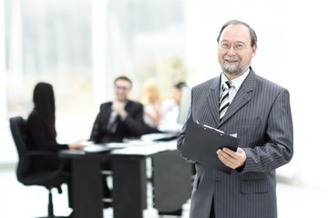 senior businessman with clipboard standing in the office.