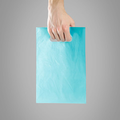 Hand holding plastic bag. Close up. Isolated on white background
