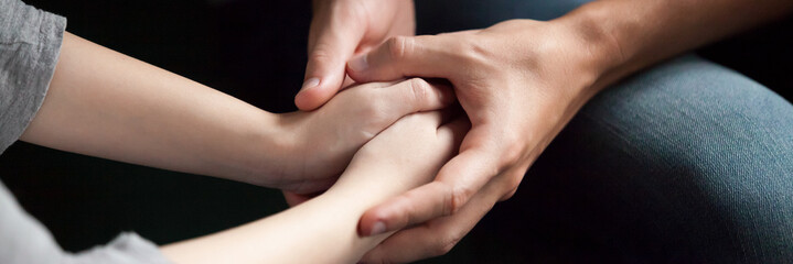 Close up man woman holds hands couple reconcile make peace after quarrel show care love empathy in...