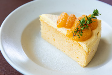 orange cake with orange fruit topping on white dish