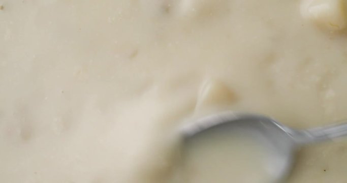 Video of stirring canned clam chowder with a spoon then taking a spoonful at the end.