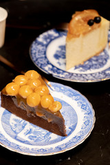 chocolate cake decorated with macadamia on dessert table at cafe, on dark table background